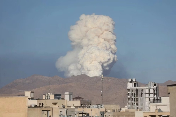 A large plume of smoke rises over a mountainous area after reported Israeli strikes on military sites in Iran in June.