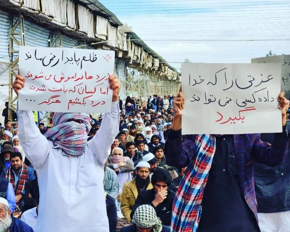 People in Zahedan carrying placards. One message says, "Oppression cannot last"