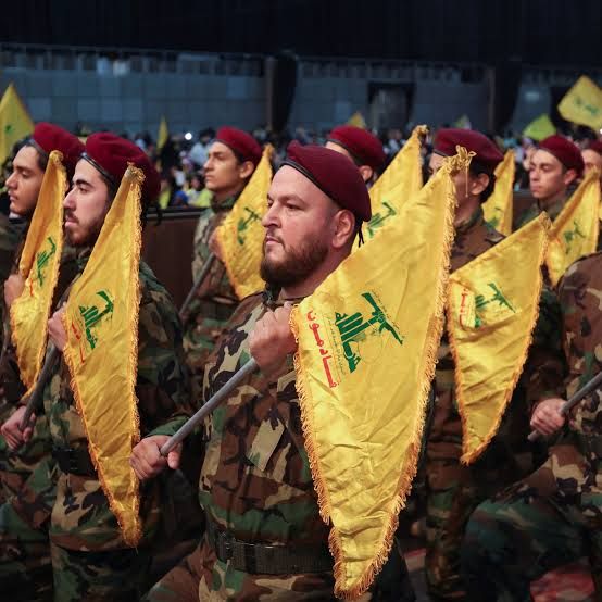 Members of Lebanon's Hezbollah hold flags during a rally 
