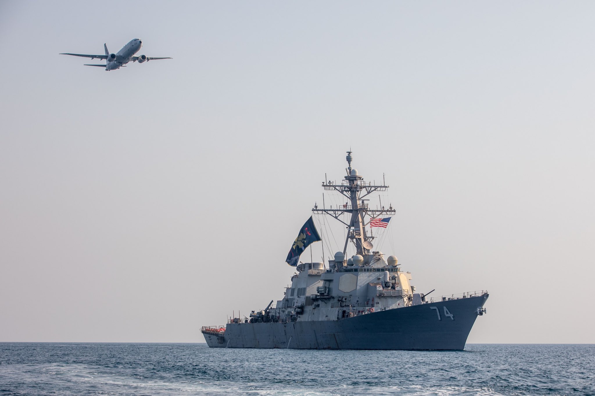 A US Navy P-8A Poseidon maritime patrol aircraft flies above guided-missile destroyer USS McFaul while patrolling the Persian Gulf, Aug. 3, 2023
