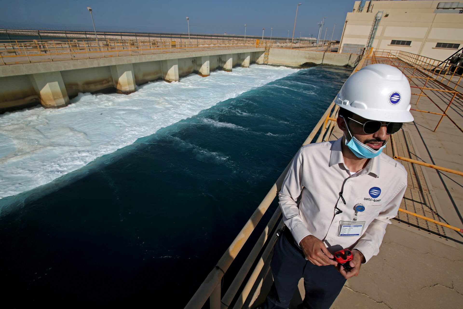 n employee stands next to a waste water collection pool at the world's largest water desalination plant at the Saline Water Conversion Corporation Ras Al-Khair Power and Desalination Plant in Ras al Khair, Saudi Arabia, October 8, 2020.
