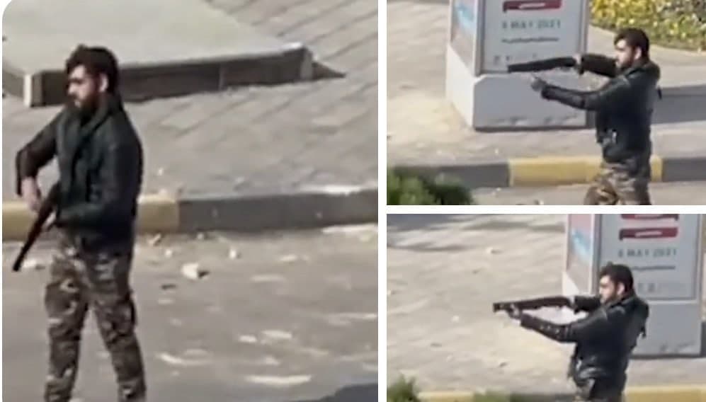 A security agent firing a shotgun at protesters in Esfahan on November 26,  2021