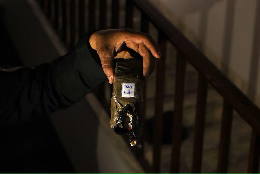 یک جنگجوی هیات تحریرالشام یک بمب خنثی‌شده C-4 را در دست دارد که در سفارت تهران در دمشق پیدا شده است