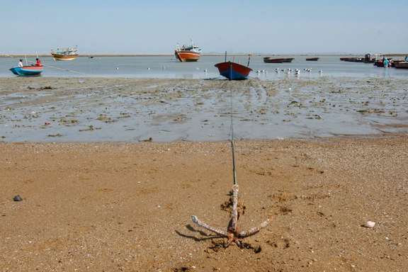 Fishing boats sit grounded at low tide along the coast in the southeastern Iranian port of Konarak, July 20, 2026