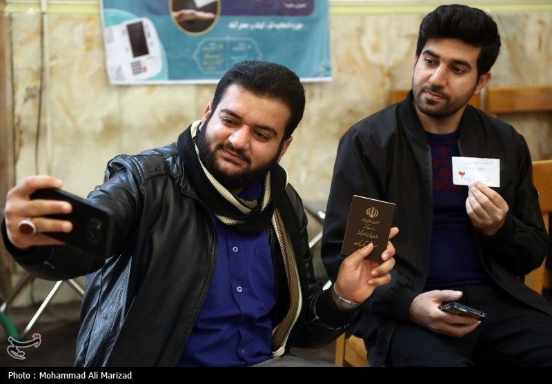 Two Iranians taking a selfie after voting in elections on March 1, 2024 