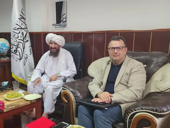 Iranian diplomat Ali Mojani (right) and a Taliban official