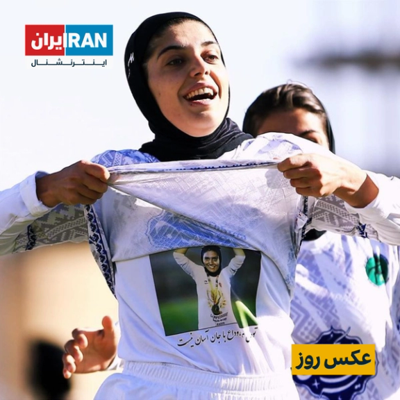 a woman takes off her shirt with a picture of a soccer player on it