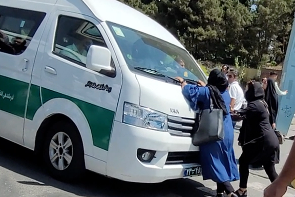 A mother trying to stop a police van that arrested her daughter for hijab. July 19, 2022