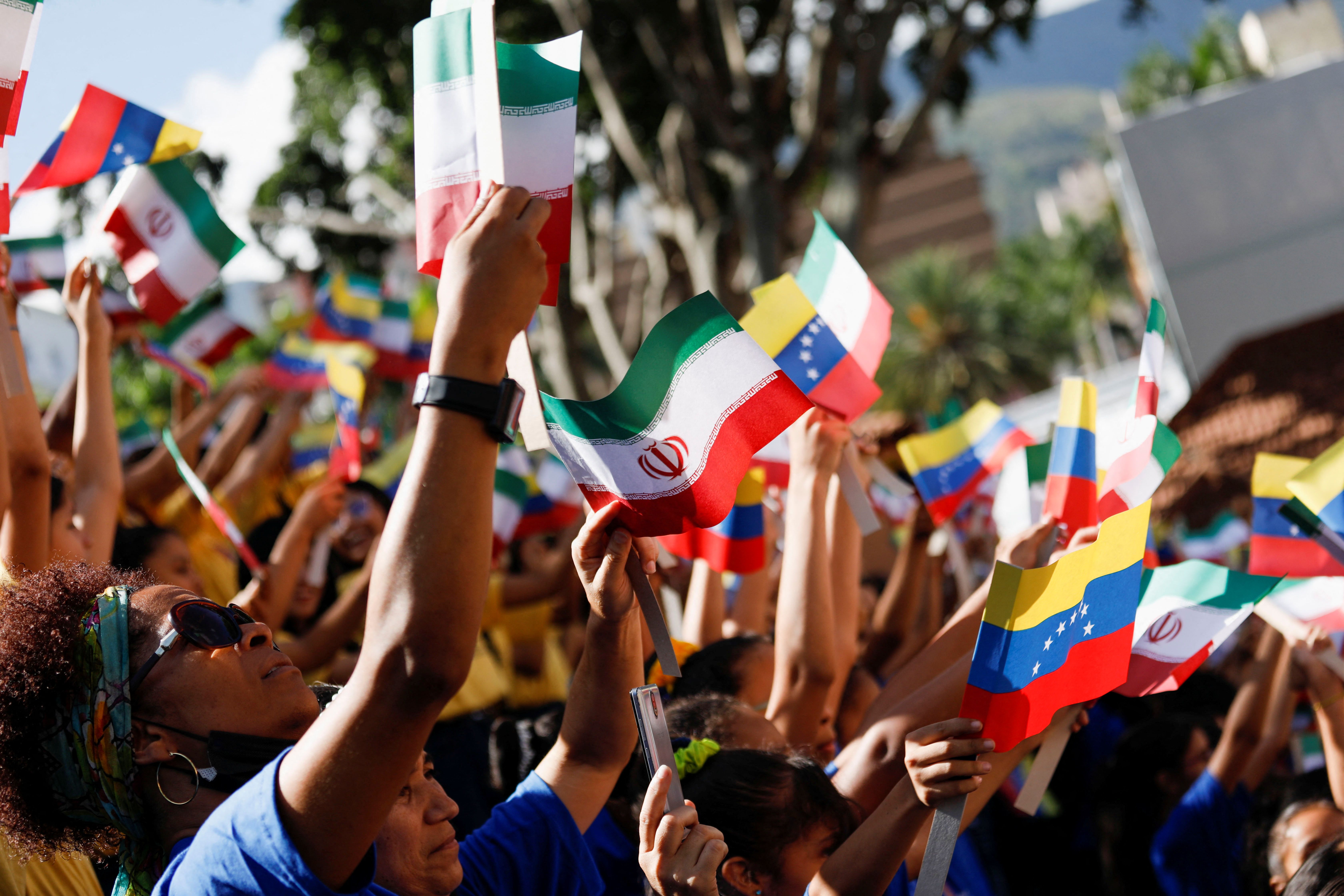 People hold flags as Venezuela's President Nicolas Maduro meets with Iranian President Ebrahim Raisi, at Miraflores Palace, in Caracas, Venezuela June 12, 2023.