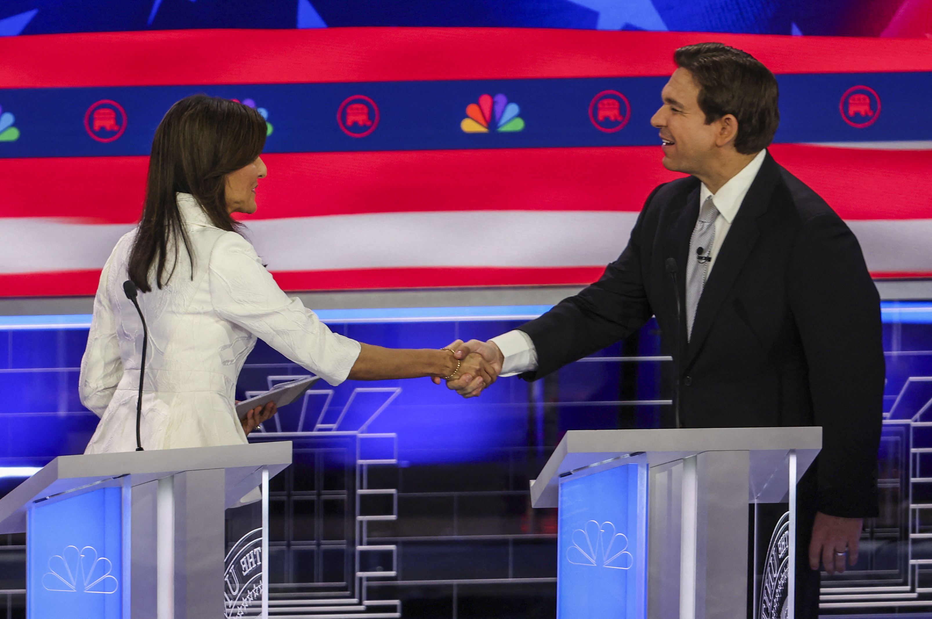 Former South Carolina Governor Nikki Haley and Florida Governor Ron DeSantis shake hands at the conclusion of the broadcast at the third Republican candidates' presidential debate in Miami, Florida, November 8, 2023. 