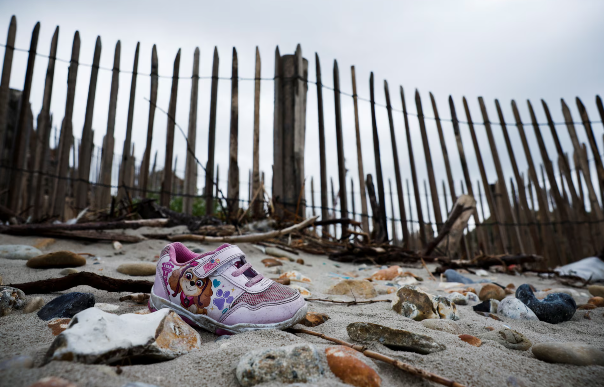 لنگه کفش باقی‌مانده از یک کودک مهاجر در سواحل منطقه ویمرو، فرانسه، ۱۴ شهریور