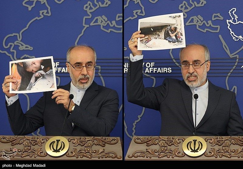 Foreign Ministry spokesman Naser Kanaani holding photos of the aftermath of the bombing on Gaza during a press conference on October 16, 2023