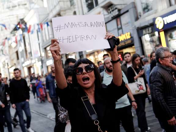 A demonstrator shouts slogans while holding up a sign during a protest in solidarity with women in Iran in central Istanbul, Turkey September 20, 2022.