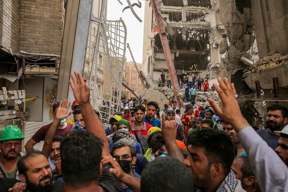 Ordinary people anxiously trying to help rescue operations where a building collapsed in Iran