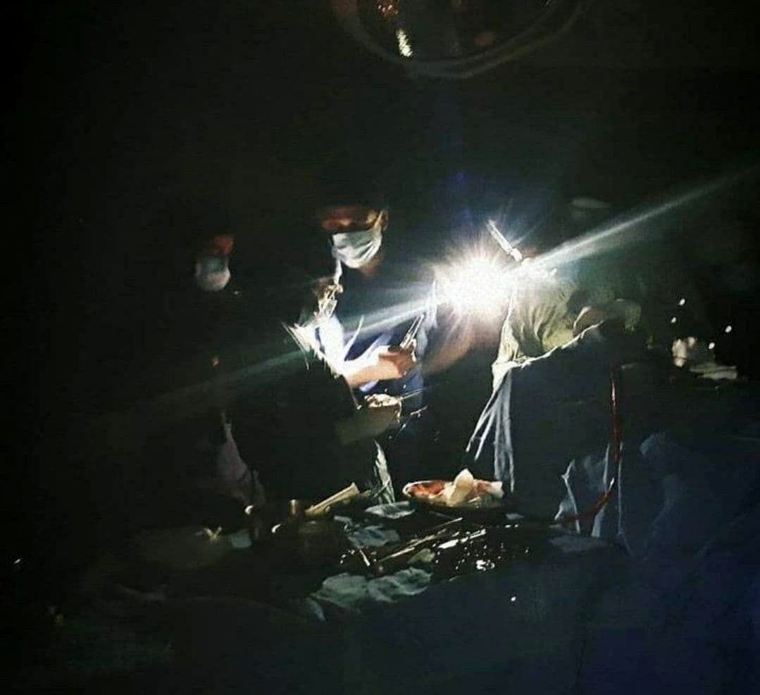 Surgeons continue an operation during a blackout in Iran, relying on flashlights for light. (Undated)