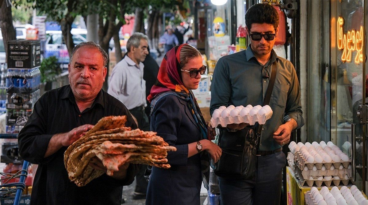 File photo of people shopping for eggs and bread at a street market in Iran amid rising food prices.