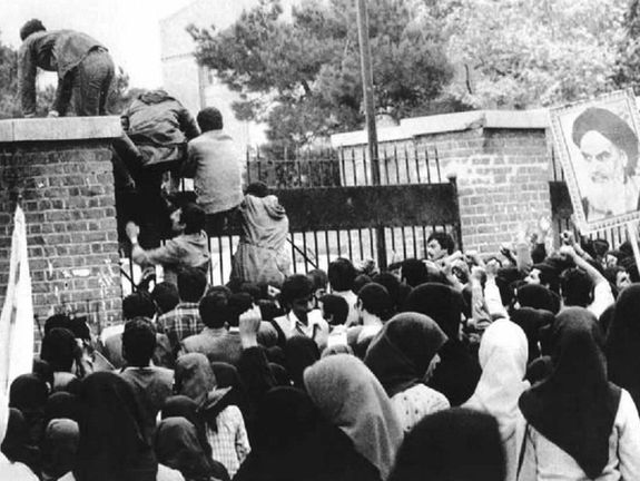 Iranian students climbing the walls of the US embassy in Tehran in November 1979.