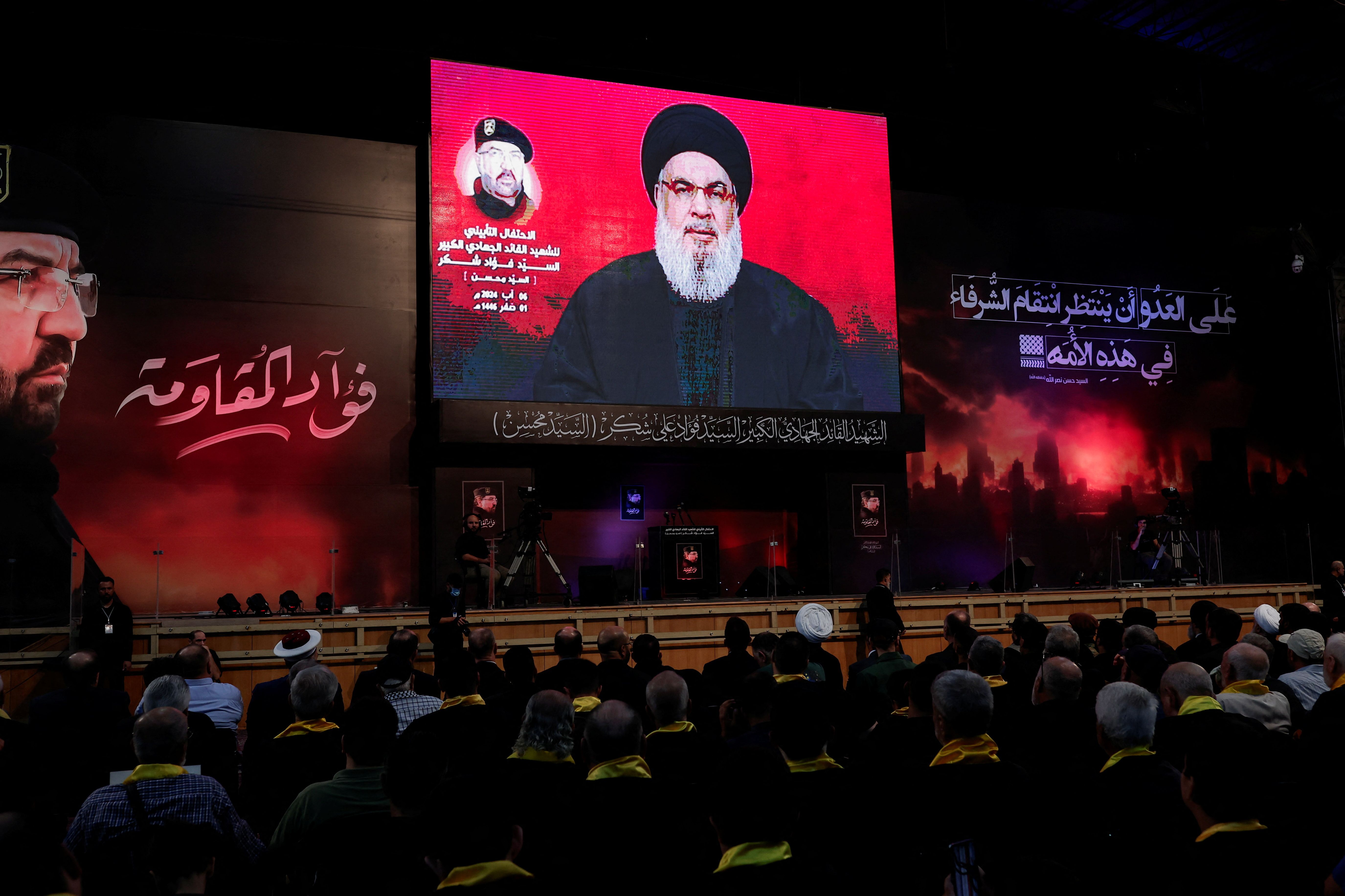 Supporters listen to the speech of Hezbollah leader Sayyed Hassan Nasrallah via a video display on screen, during a commemorative ceremony marking the first week since the killing of Hezbollah's top commander Fuad Shukr, in Beirut, Lebanon August 6, 2024. 
