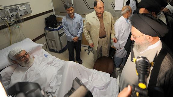 Ayatollah Kazem Nourmfidi, the representative of the Supreme Leader in the northern Golestan province visiting Supreme Leader Ali Khamenei (left) at hospital in 2014
