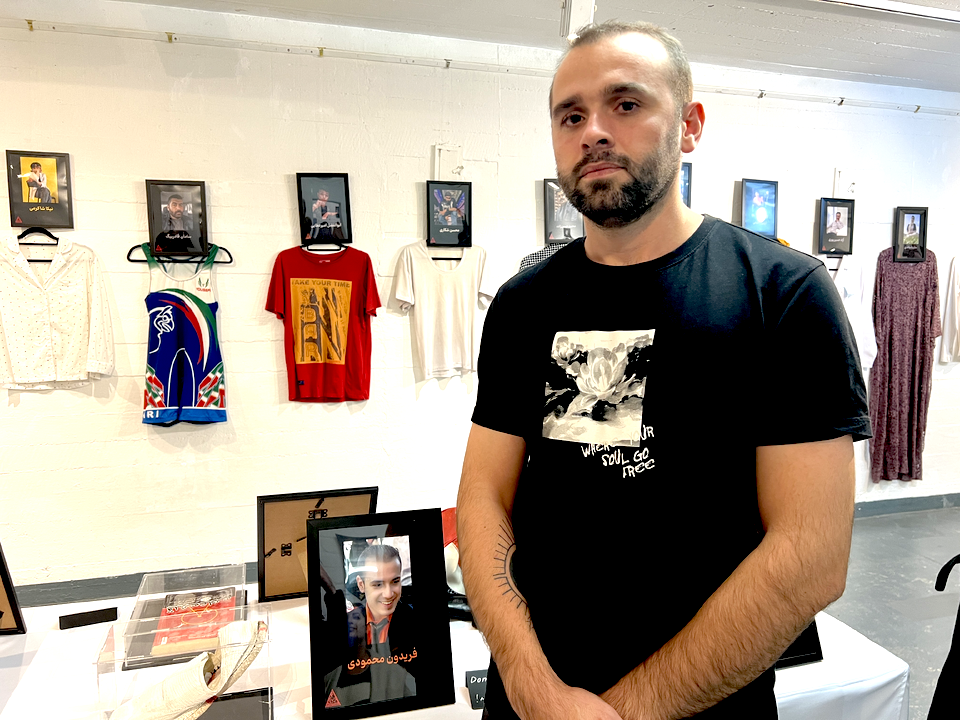 Slain protestor Fereydoon Mahmoudi's brother standing next to Fereydoon's shoes 