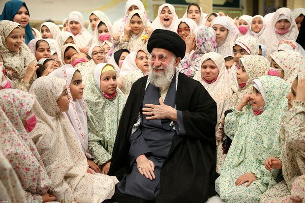 Iran’s ruler Ali Khamenei among a group of schoolgirls  