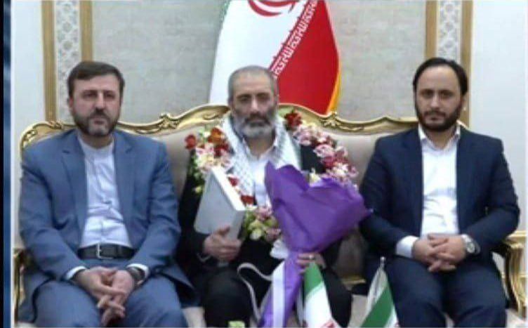 Assadollah Assadi (center) received a hero's welcome by government spokesman Ali Bahadori Jahromi (right) and Kazem Gharibabadi, the deputy head of the Judiciary who is also secretary of the High Council for Human Rights as well as several other officials.