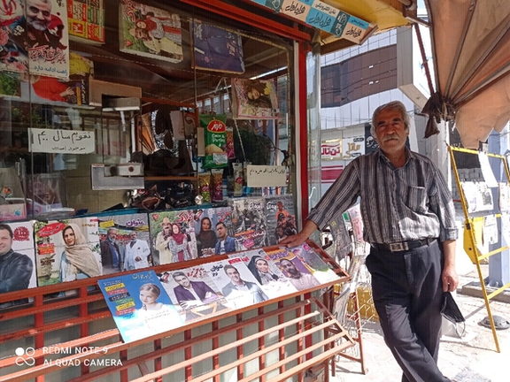 A man standing at a newspaper kiosk in Iran