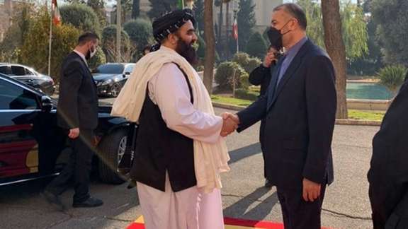 Afghan Foreign Minister Amir Khan Muttaqi shakes hands with Iranian Foreign Minister Hossein Amir-Abdollahian during a visit to Tehran on January 9, 2022.