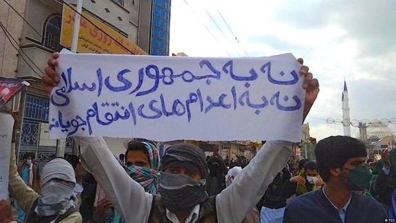 An Iranian holding a banner against the regime’s executions during a protest rally in the city of Zahedan