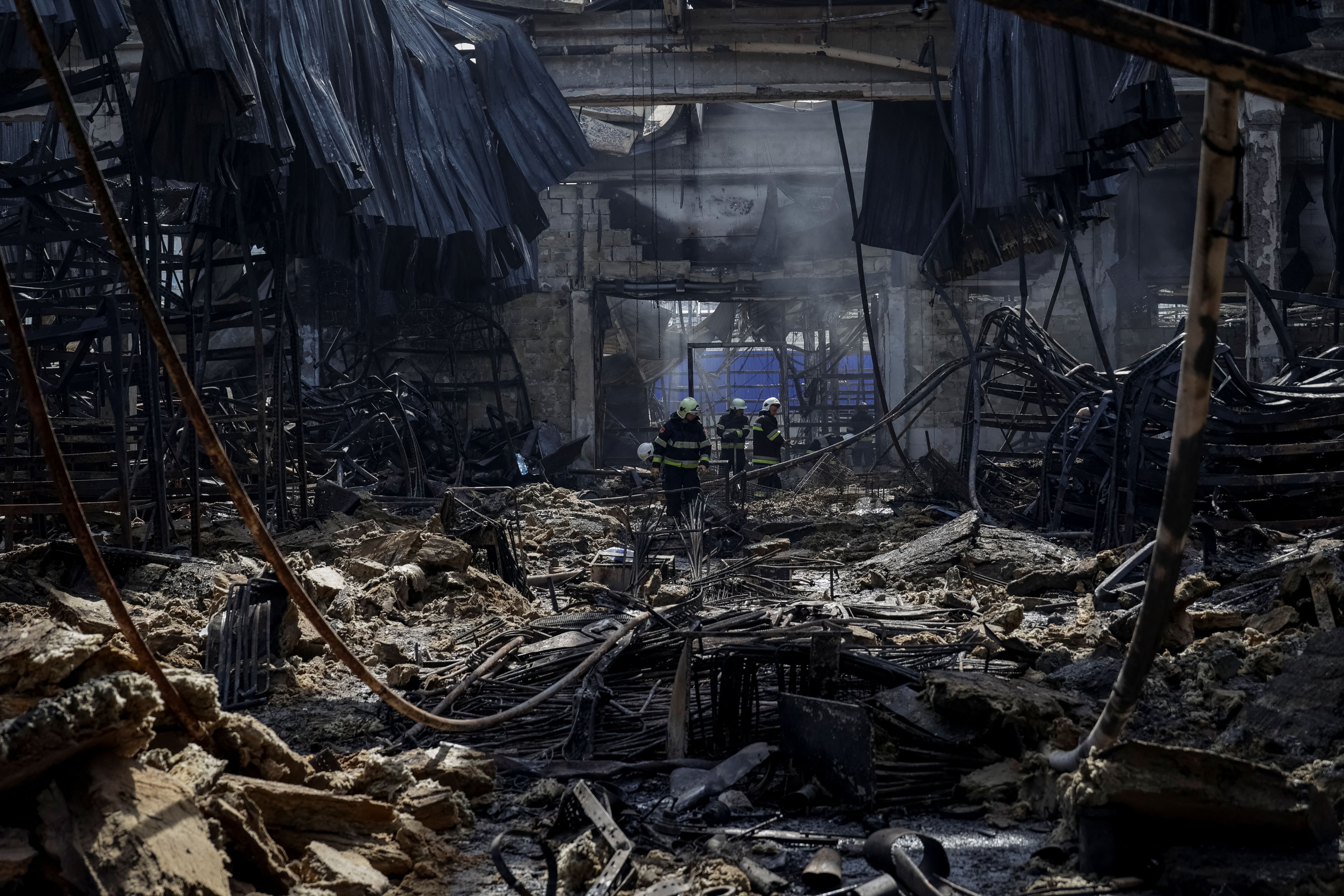 نیروهای امدادی در میان ویرانه‌های یک فروشگاه در شهر خارکیف اوکراین پس از حمله مرگبار روسیه، ششم خرداد