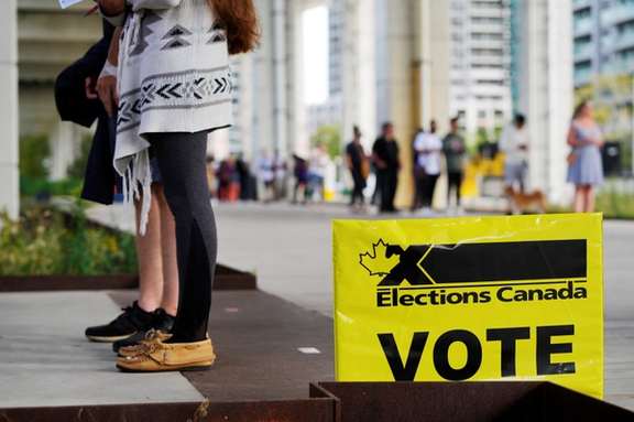 People line up outside a polling station to vote in Canada's federal election, in Toronto, Ontario, Canada September 20, 2021.