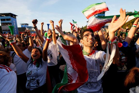 Supporters of Iran celebrate while watching the match in a fan zone.