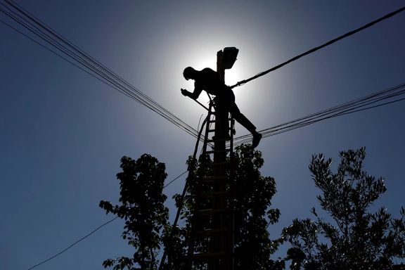 An Iraqi technician works on an electricity pole in this file photo in Iraq.