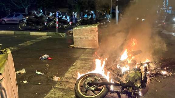 Protesters set a riot police motorcycle on fire in Tehran on September 19, 2022