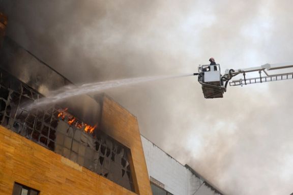 A firefighter sprays water on blazes of a shopping mall in Iran's northern city of Anzali, July 22, 2025