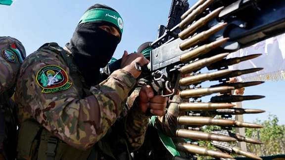 A Palestinian fighter from the armed wing of Hamas takes part in a military parade to mark the anniversary of the 2014 war with Israel, near the border in the central Gaza Strip, July 19, 2023.