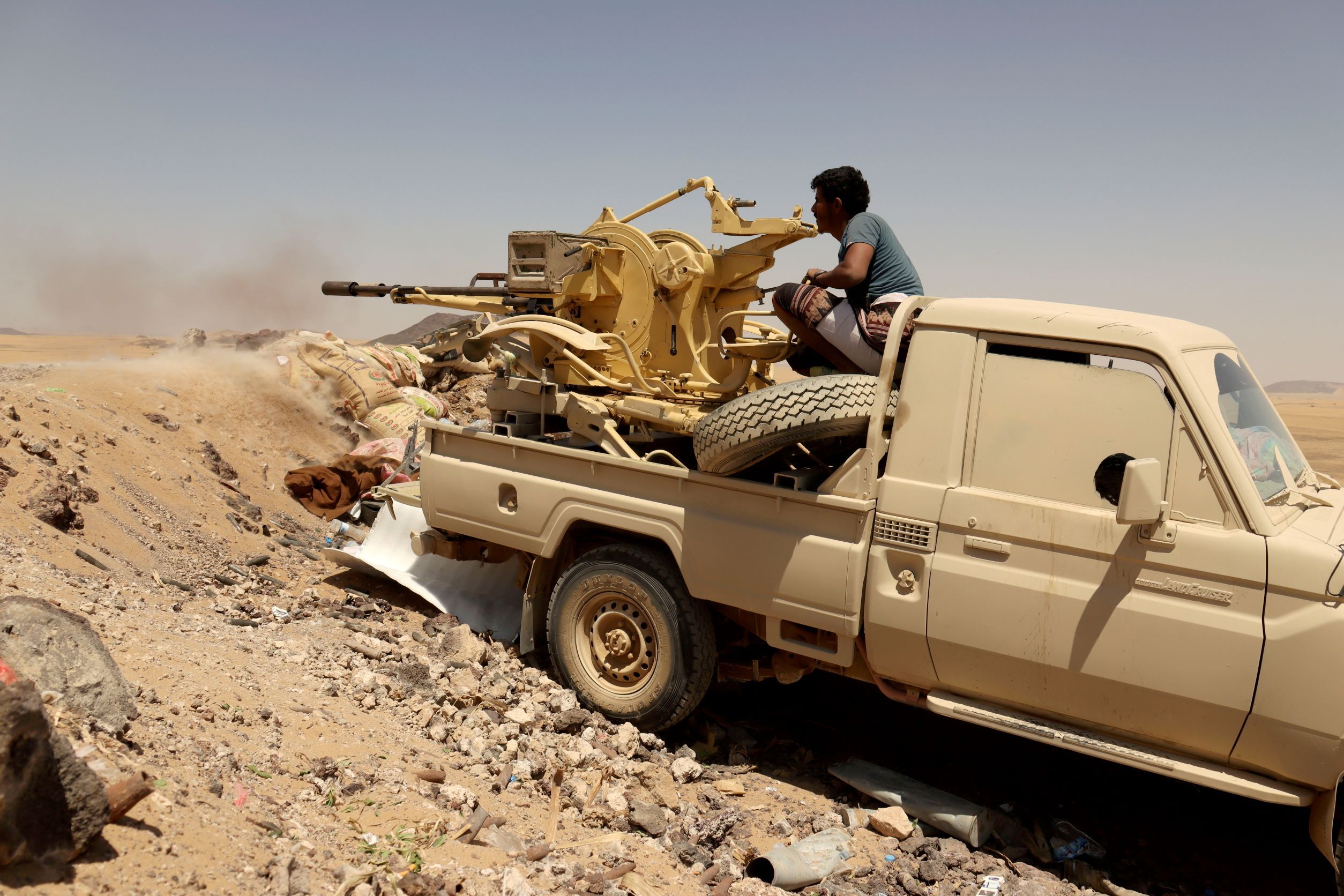 A Yemeni government fighter fires a vehicle-mounted weapon at a frontline position during fighting against Houthi fighters in Marib, Yemen March 28, 2021