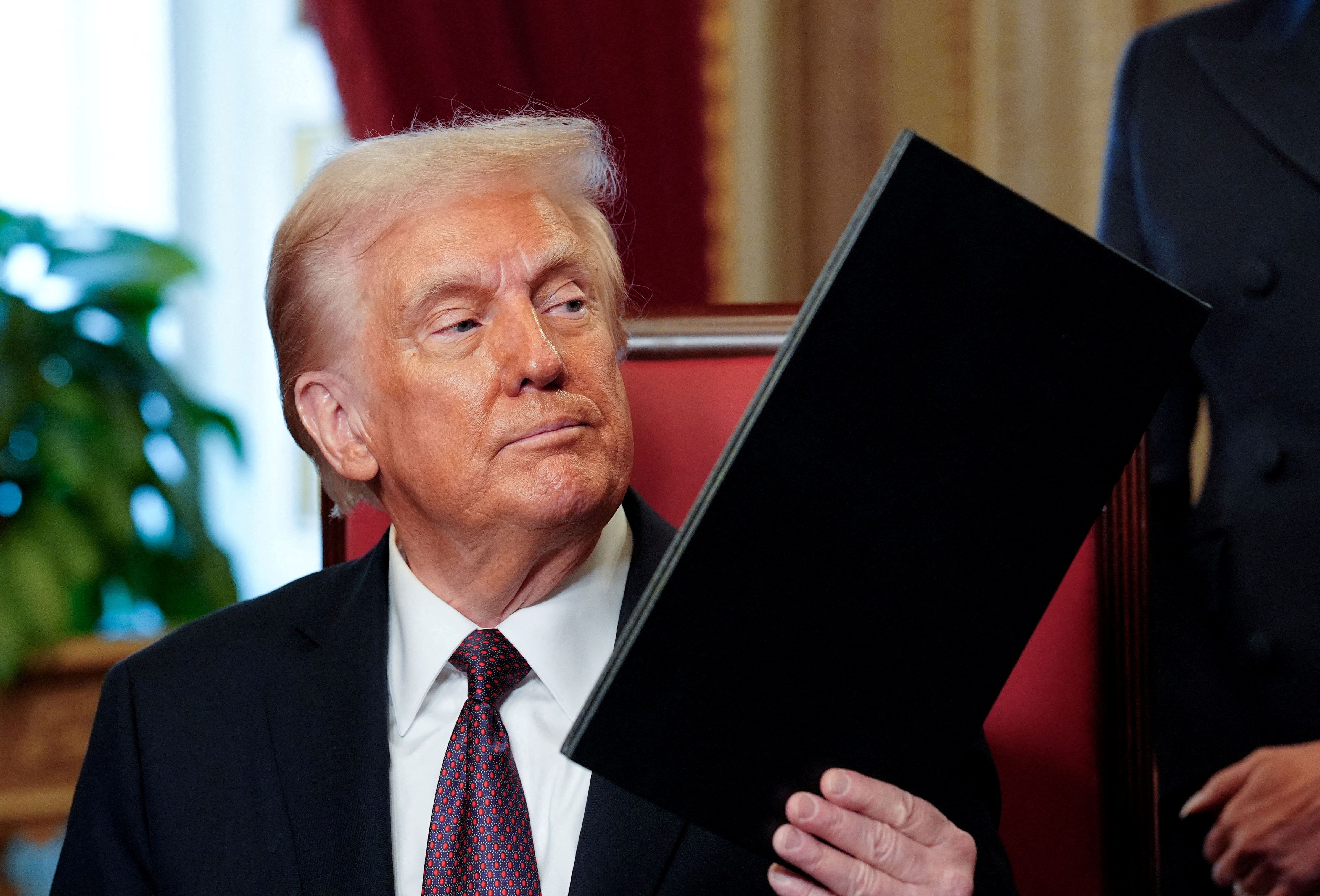 US President Donald Trump holding a signed executive order