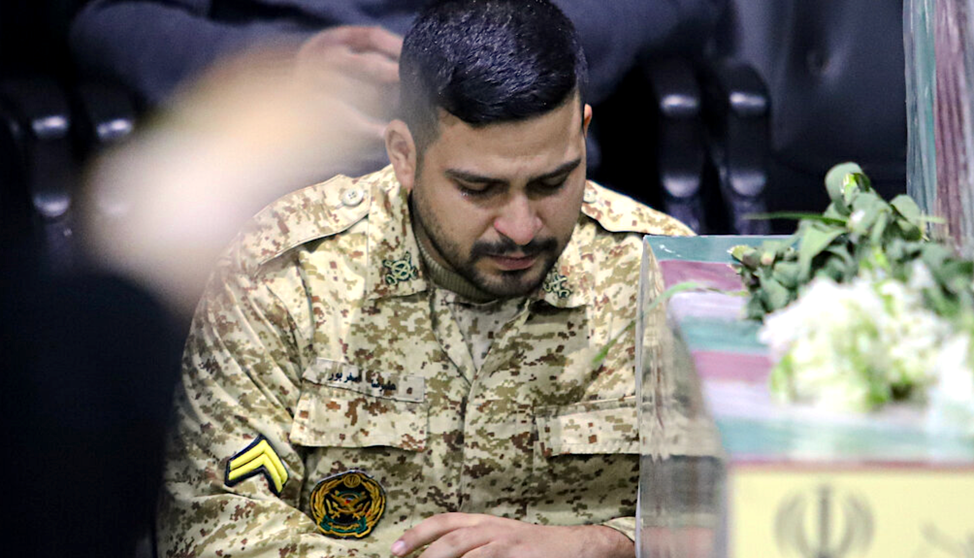 A soldier from Fatemiyoun brigade mourns at the funeral of a comrade killed in Syria, January 8, 2024