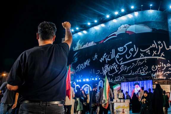 A man gestures toward a giant anti-Trump billboard during a nightly state-backed rally in Tehran, July, 25, 2026