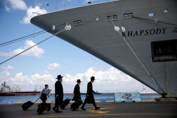 Ultra-Orthodox Jewish people carry their belongings before boarding a ship for US nationals and their immediate family members, as they leave Israel headed for Cyprus, amid the ongoing conflict between Israel and the Palestinian Islamist group Hamas, in Haifa, Israel, October 16, 2023.
