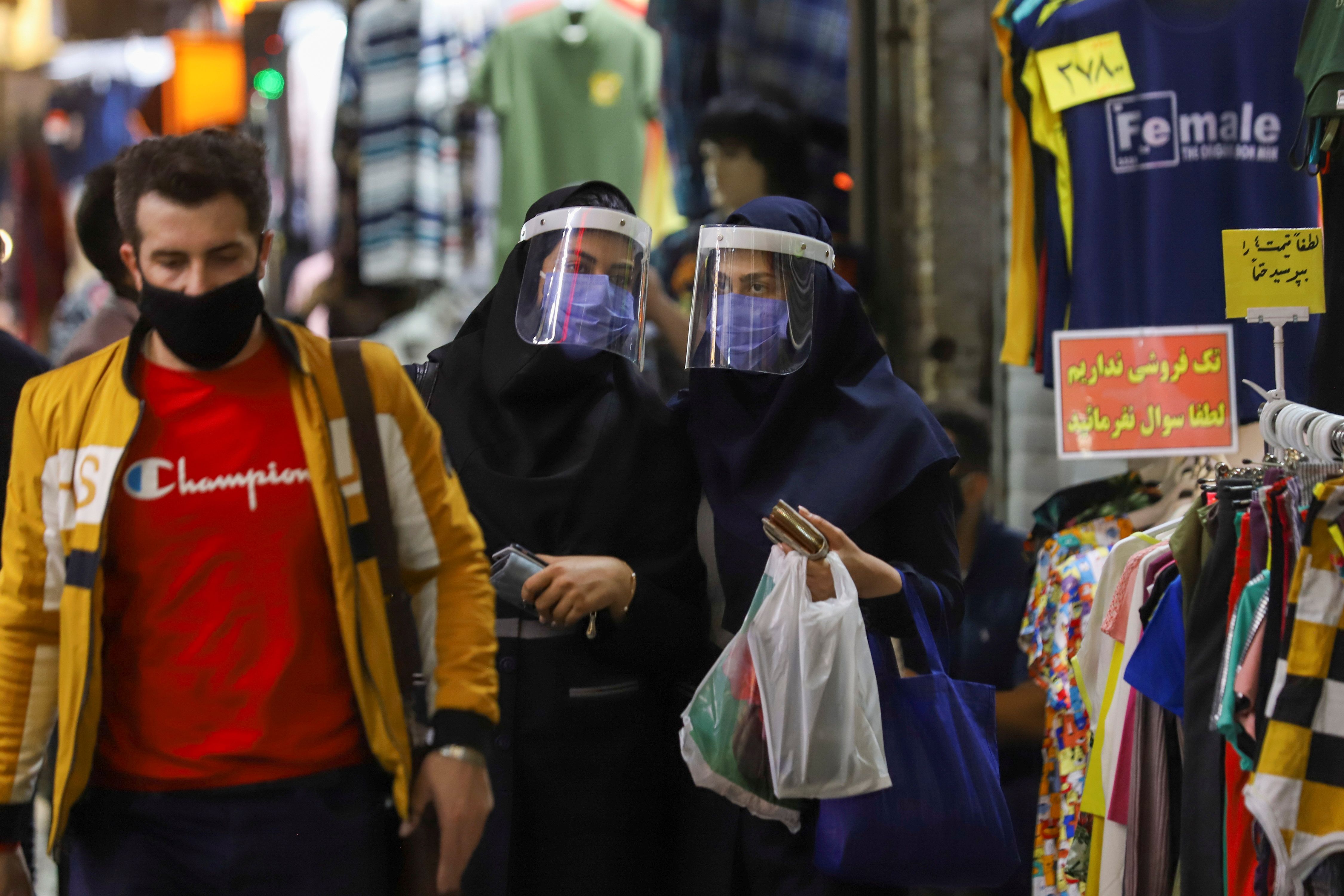 Iranian women wear protective face shields and masks as they walk in Tehran Bazaar in Tehran, Iran April 6, 2021. 