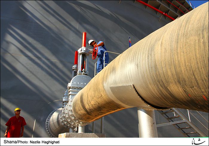 Workers service oil industry infrastructure in Iran