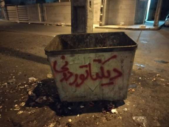 Protesters have written "Dictator disposal" on a garbage bin in Tehran. October 2022