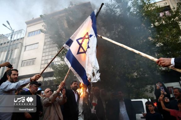 People burning the Israeli flag during a regime-sponsored rally in support of Hamas in Tehran on October 18, 2023
