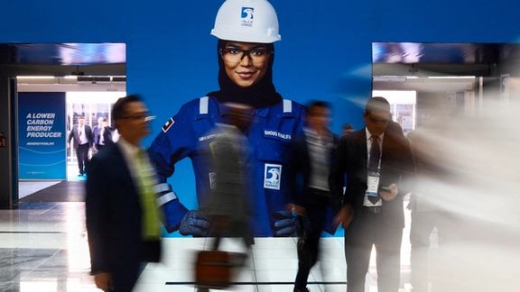 People walk by a Abu Dhabi National Oil Company (ADNOC) poster during the Abu Dhabi International Petroleum Exhibition and Conference (ADIPEC) in Abu Dhabi, United Arab Emirates, October 31, 2022.