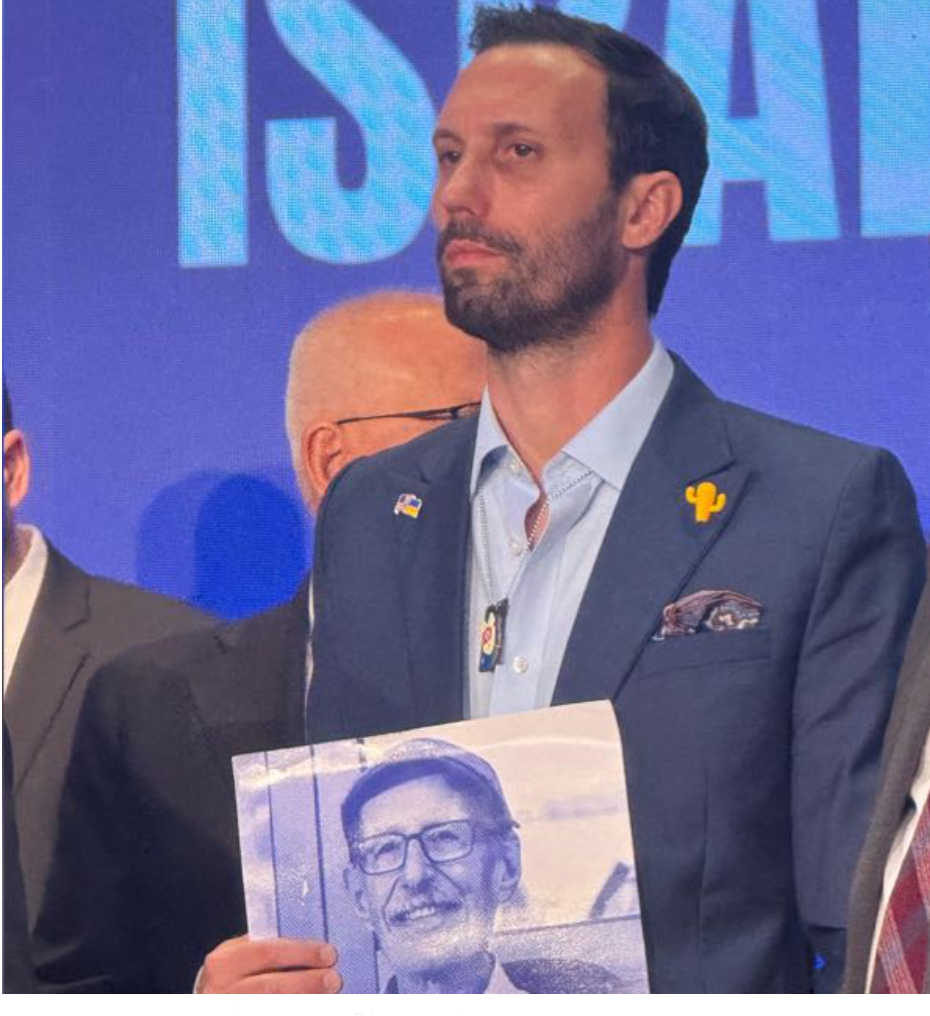 Daniel Lifshitz holding a photo of his grandfather Oded Lifshitz.
