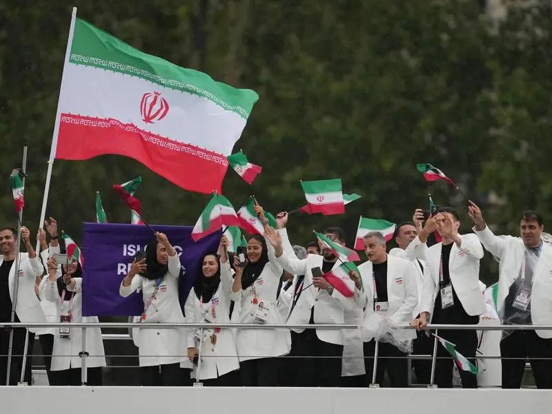 The Iranian team waves their flags in their official attire during the parade at the 2024 Paris Olympics on July 26, 2024.