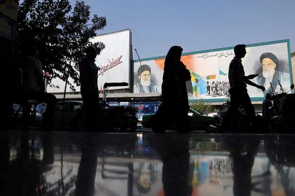 People walk past a mural depicting the late leader of the Islamic Republic Ruhollah Khomeini and Supreme Leader Ali Khamenei on a building in a street in Tehran, Iran, October 7, 2024.