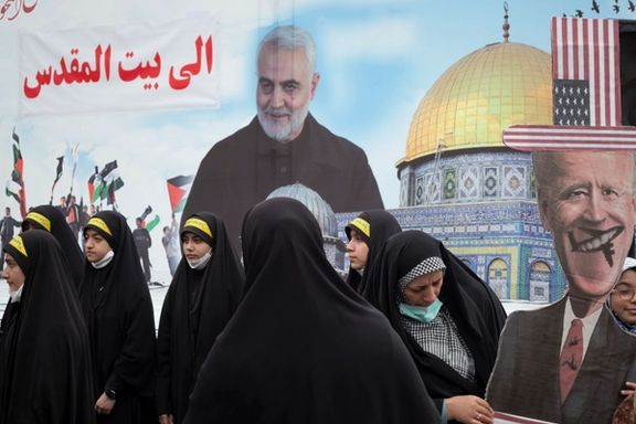 Women in front of a poster on Quds Day that says "on to Jerusalem" in April 2022